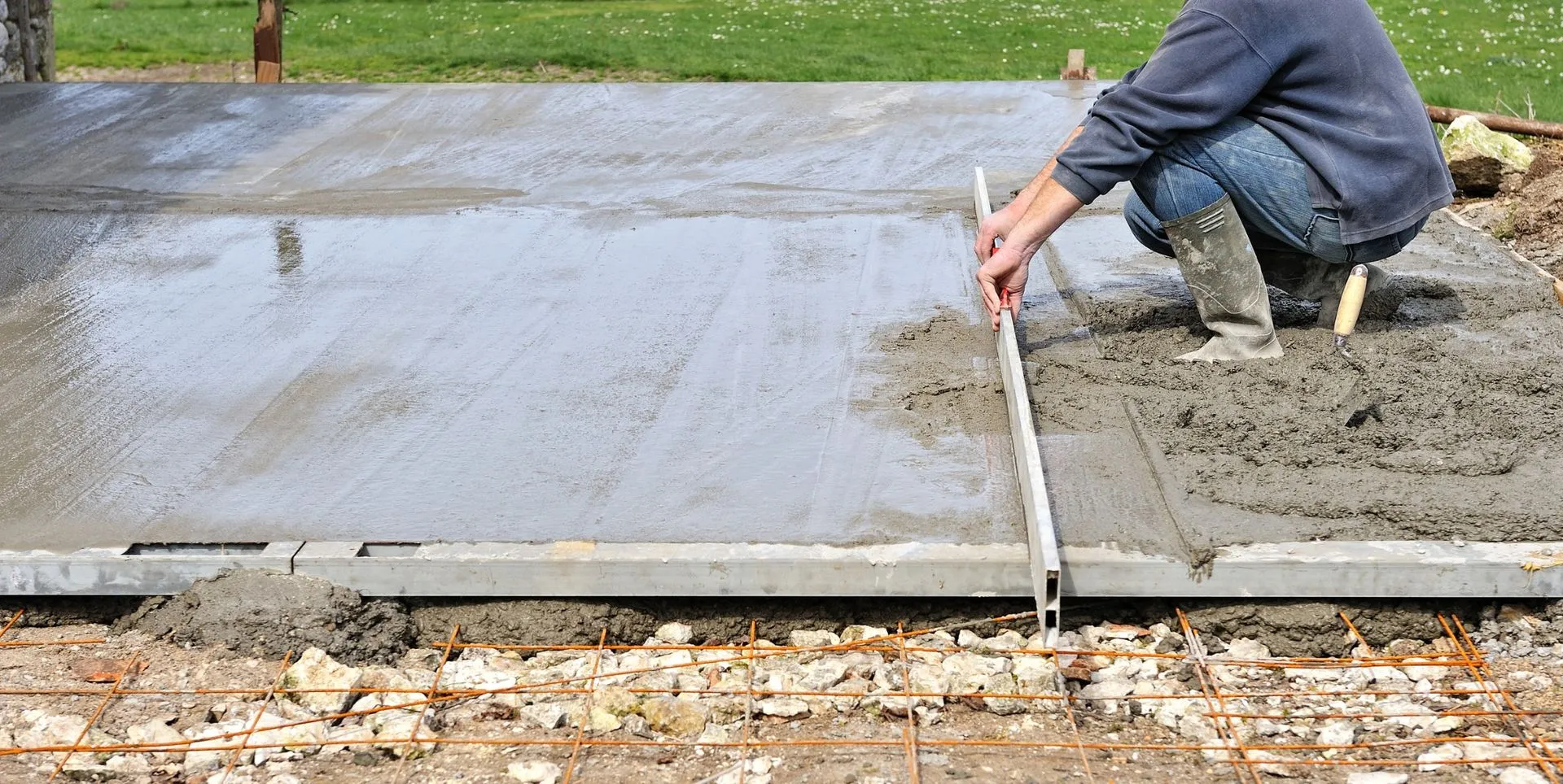 a local contractor is leveling the wet concrete to finish the patio slab