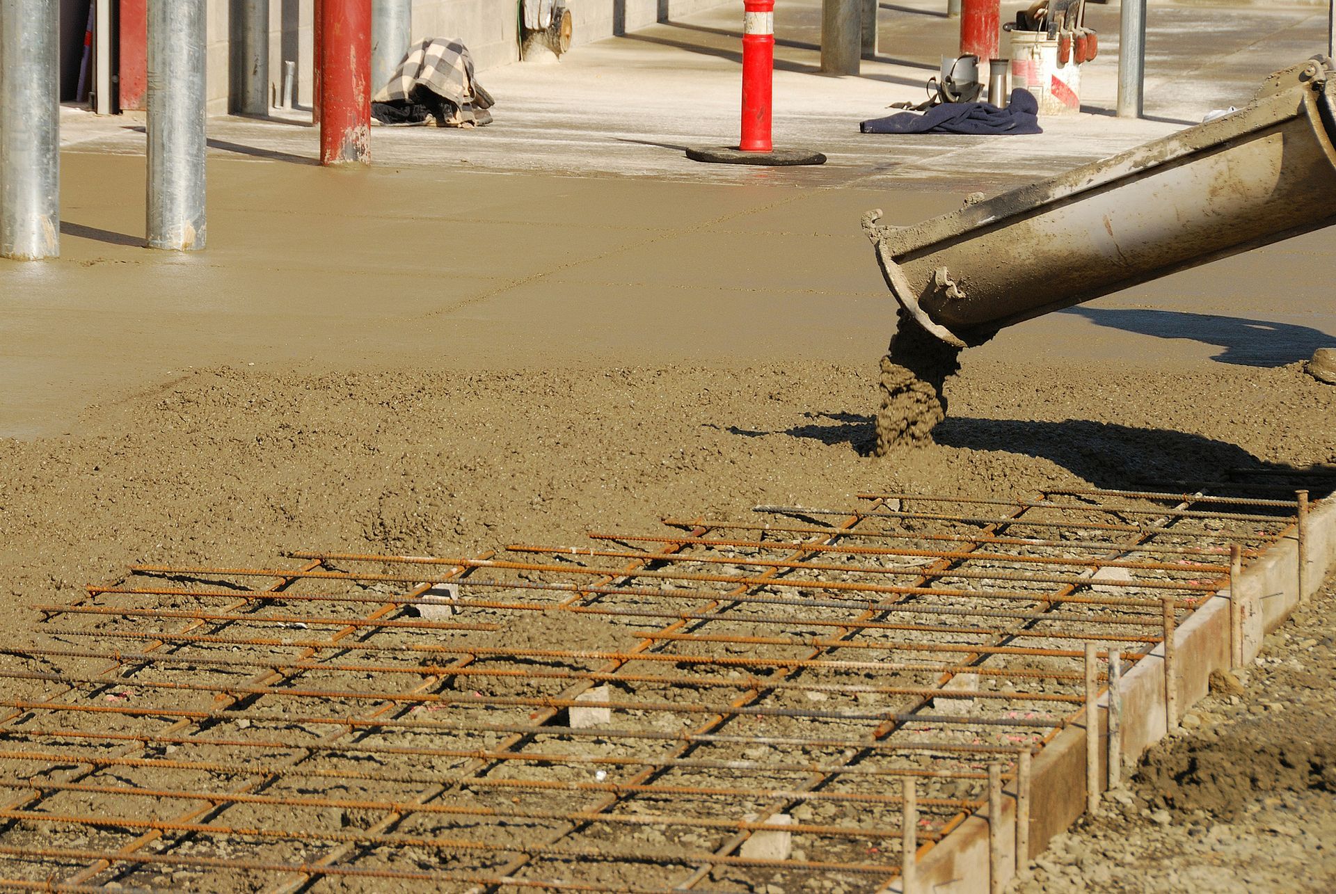 wet concrete mixture is poured into a frame using a specialized equipment
