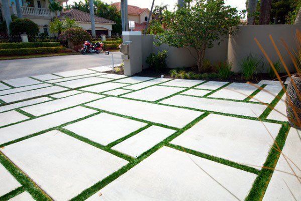 artificial grass installed between rectangular-shaped concrete pavers for this driveway in Delray Beach FL