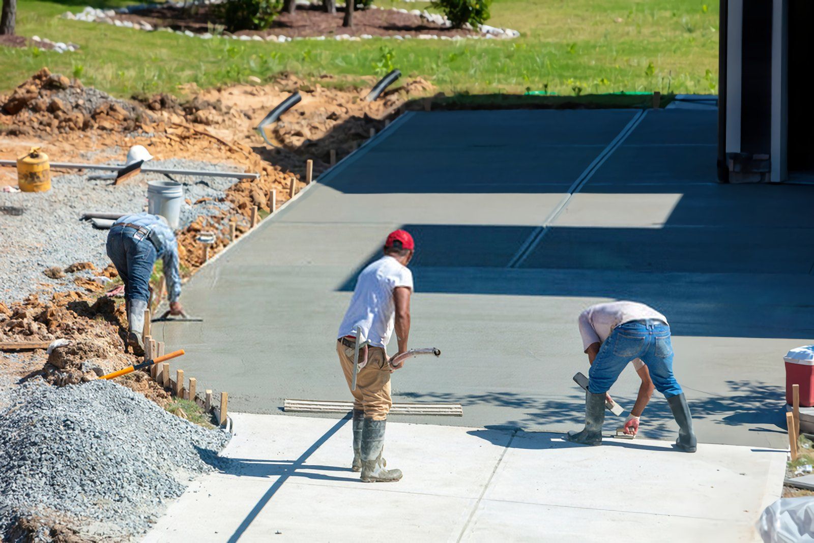 local contractors using leveling tools to create a smooth concrete driveway surface