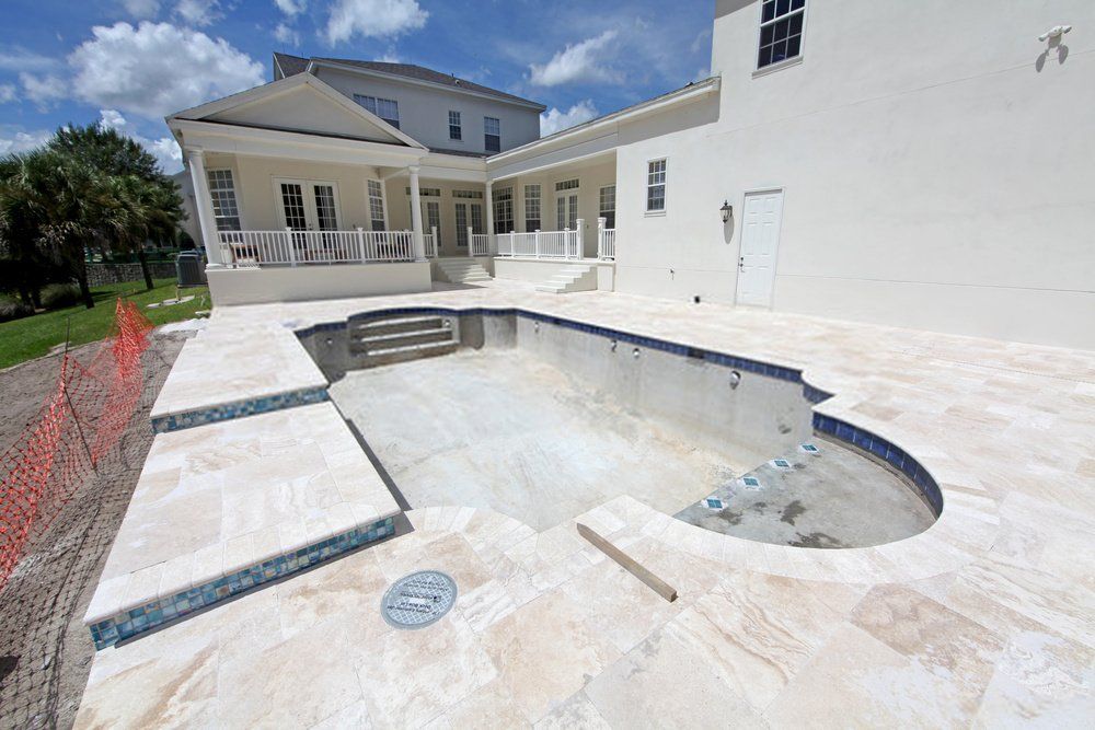 this newly resurfaced pool deck in Boynton Beach is rounded off with stamped concrete