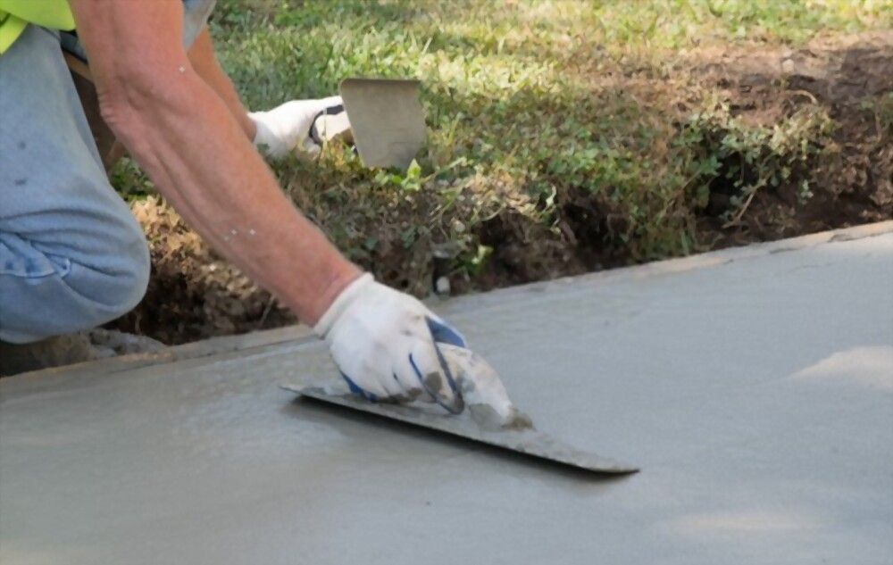 local concrete contractor using a hand trowel to finish this newly resurfaced walkway